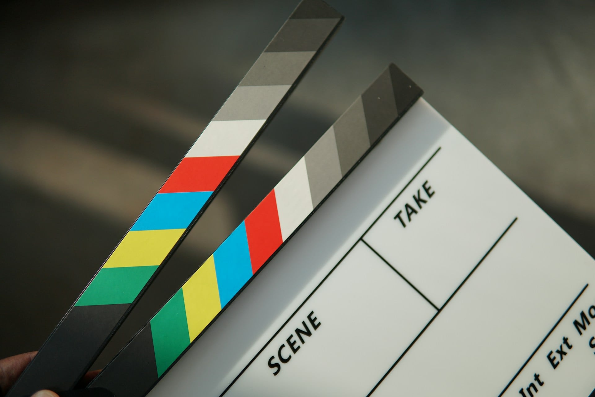 A film clapperboard with colorful striped sticks and a blank scene slate.