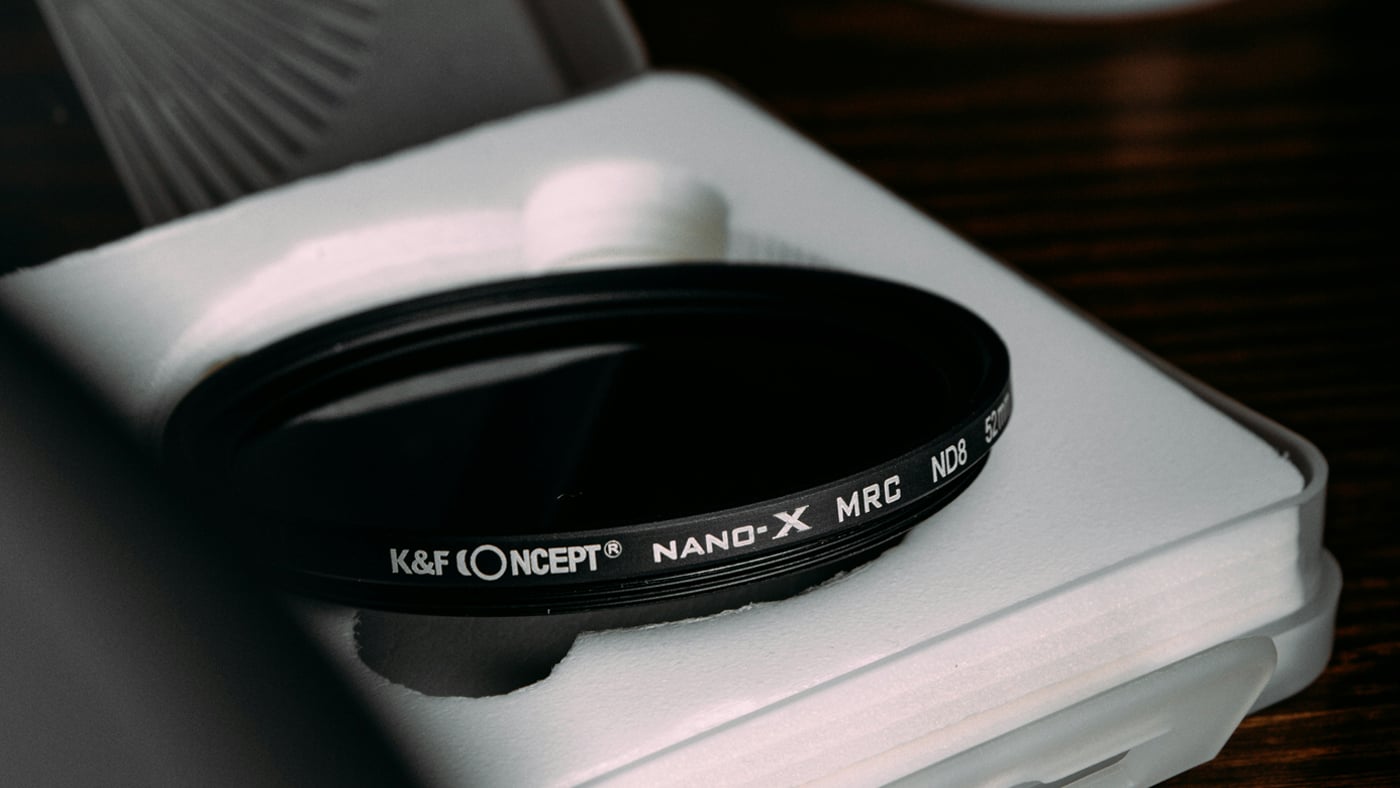 Close-up of a K&F Concept Nano-X MRC ND lens filter resting in its white plastic case.
